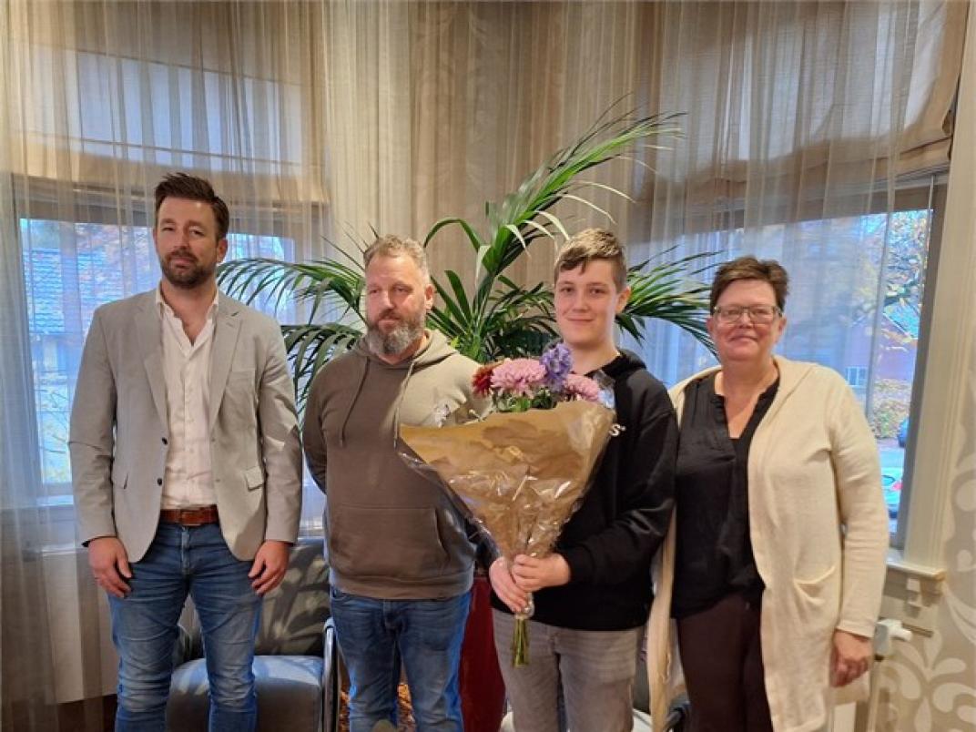 Foto van Ruben en zijn ouders en de wethouder