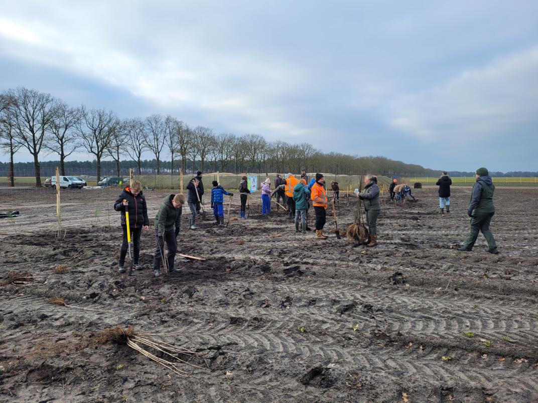 Foto van leerlingen op het land met schep in de hand.