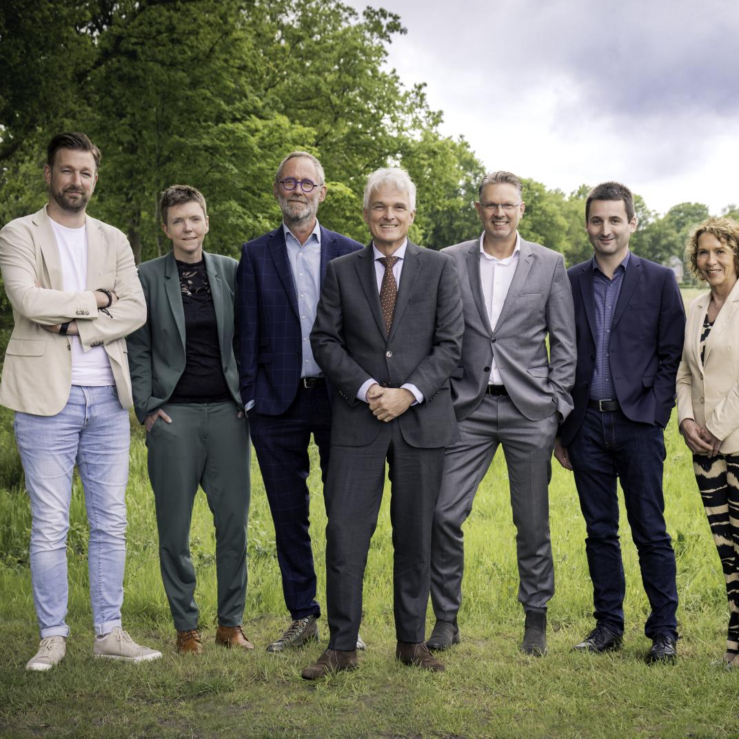 decoratief: 7 personen op een foto: 6 wethouders en burgemeester staat ervoor